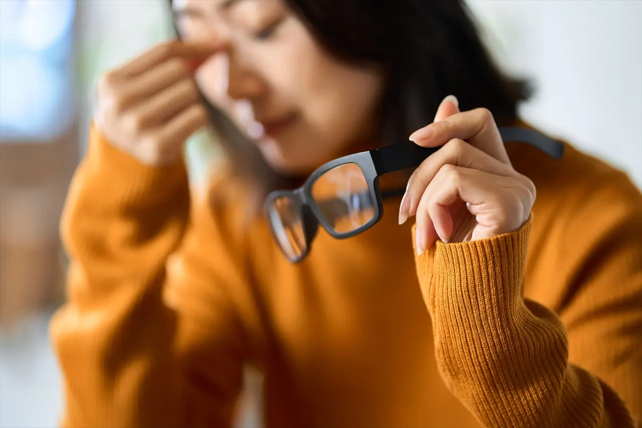 疲れ目でつらそうな女性