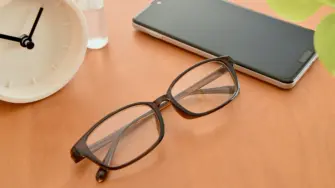 机に置かれたメガネとスマホ