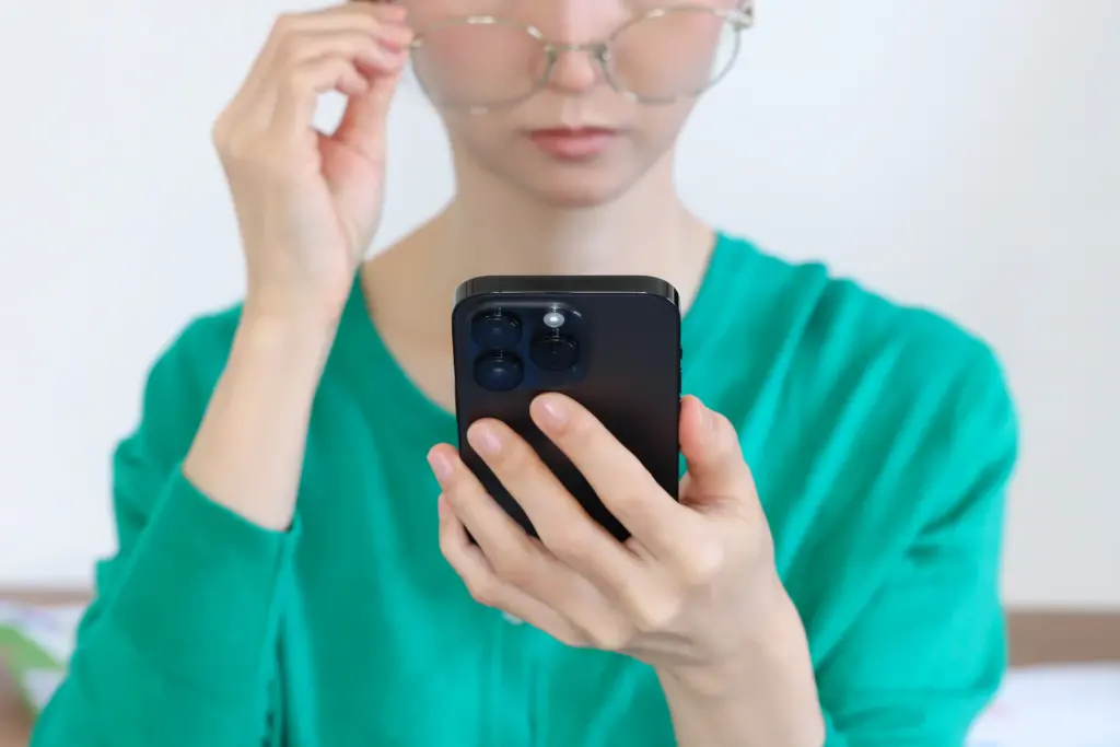 スマートフォンを見る老眼の女性
