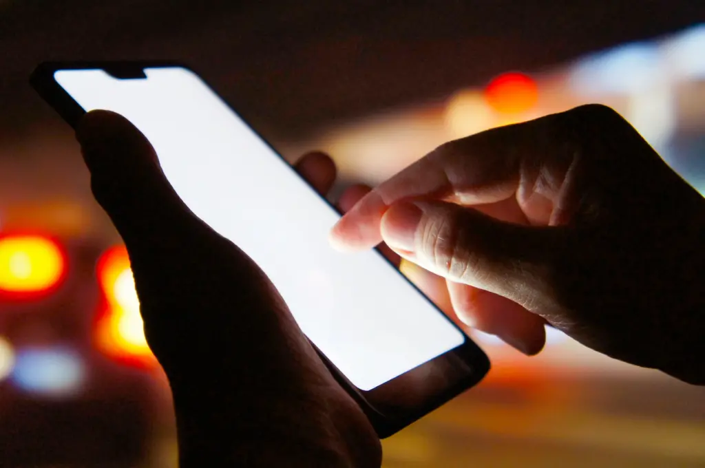 夜にスマホを使うイメージ