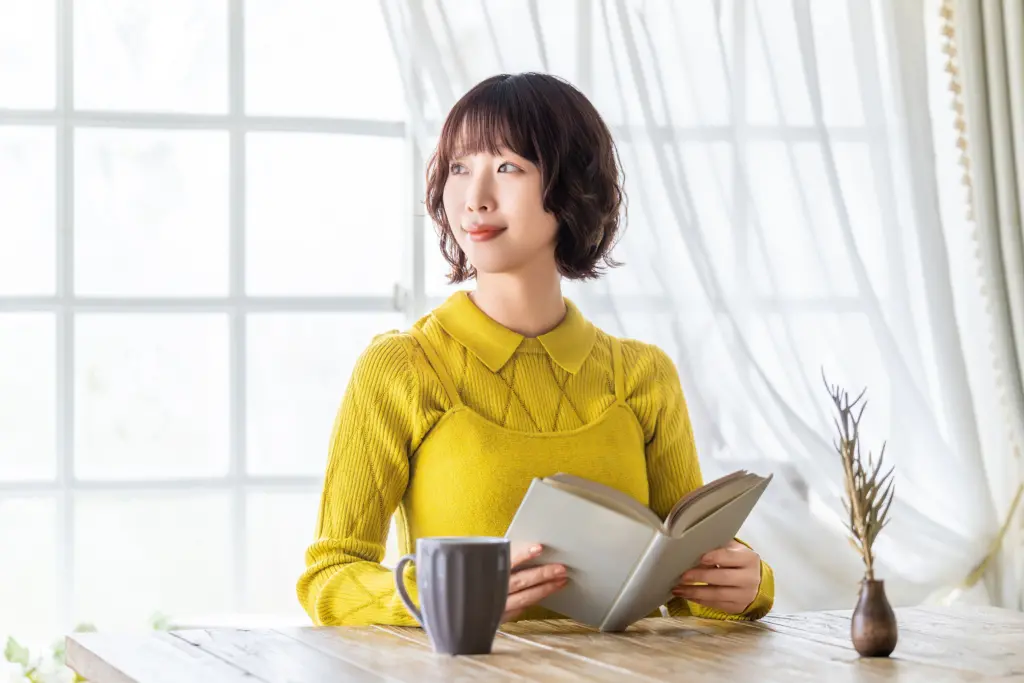 読書中に遠くを眺めて目を休める女性