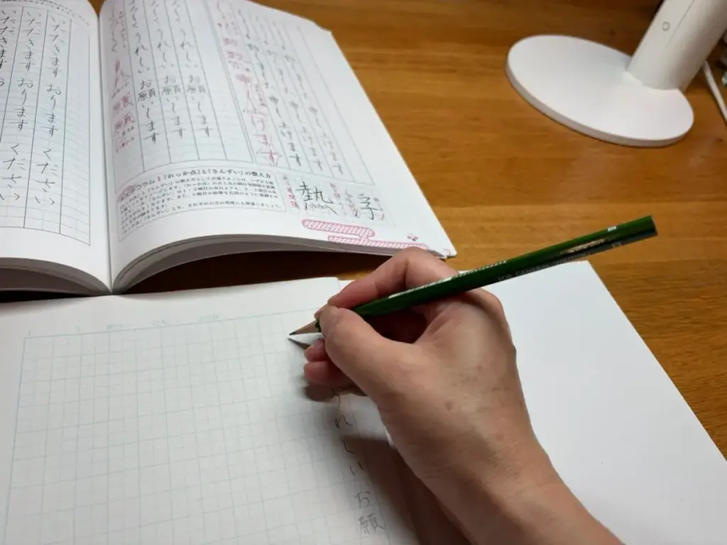 右利きでデスクライトを右側に置き文字を書くと手元に影ができる様子