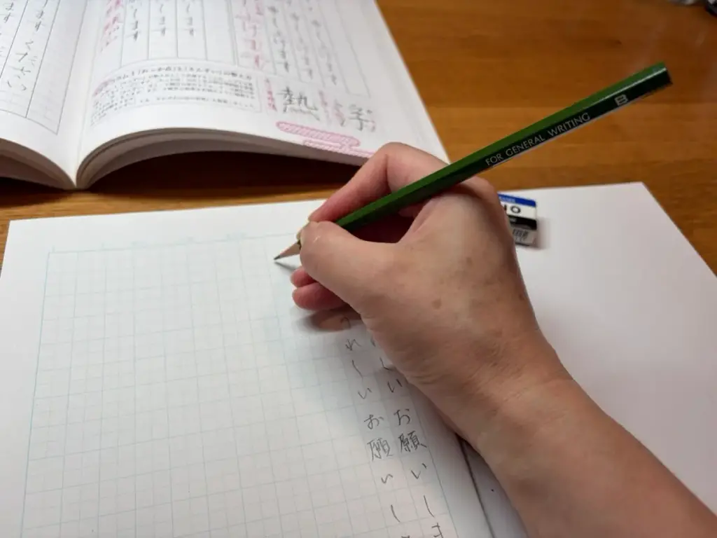 右利きでデスクライトを左側に置き手元の影を抑えて文字を書く様子