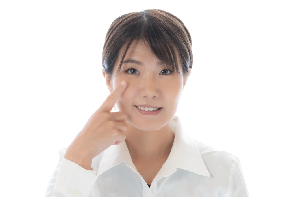 目を指さす女性