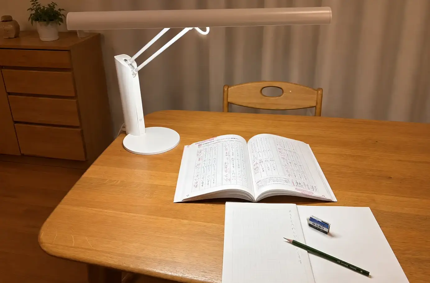 デスクライトで教科書とノートを照らした学習机