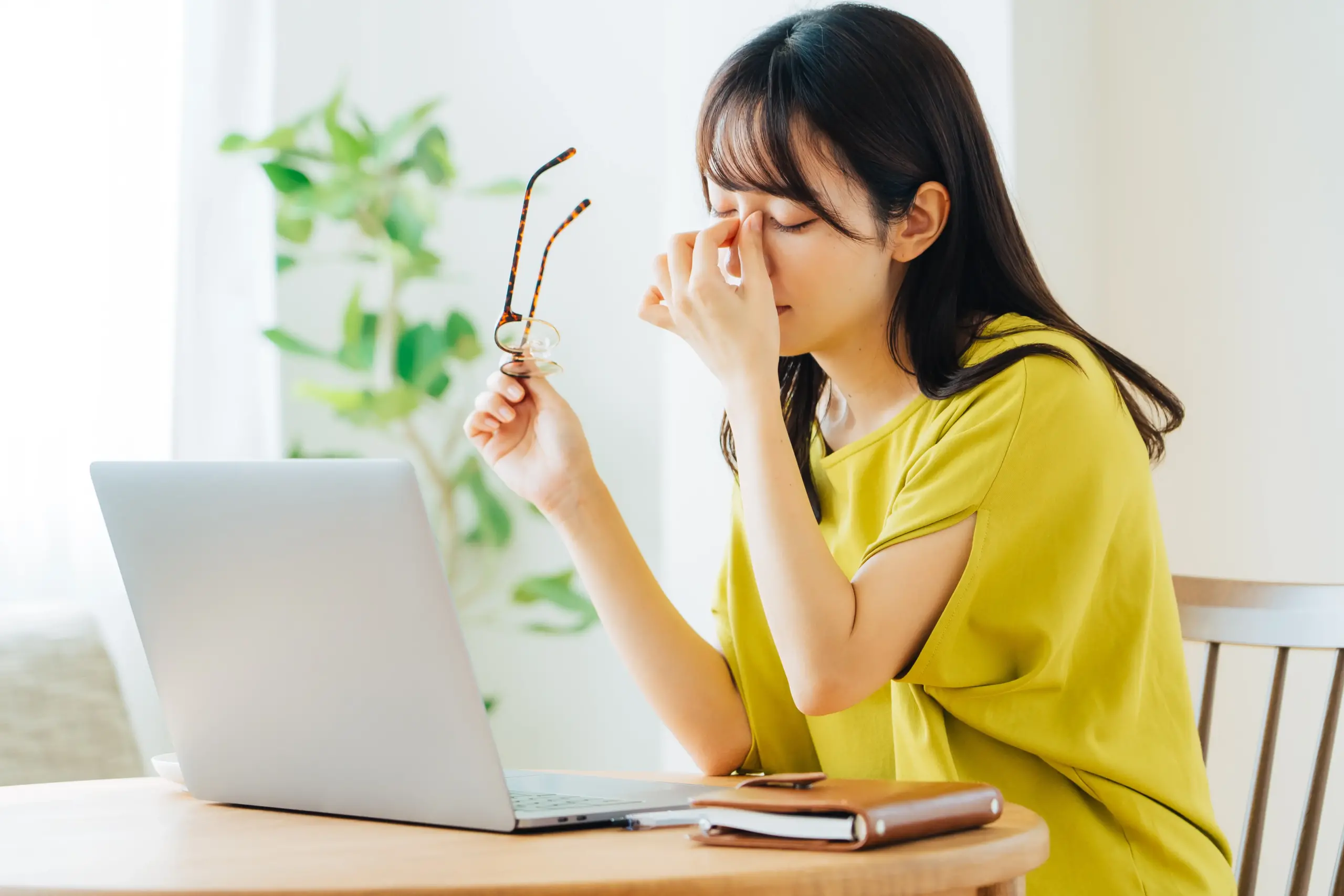 パソコン作業中に疲れを感じている女性